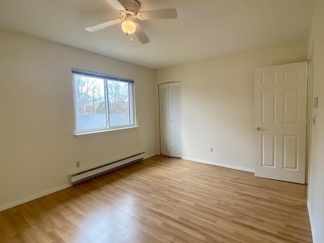 spare room featuring baseboards, ceiling fan, light wood-style flooring, and baseboard heating