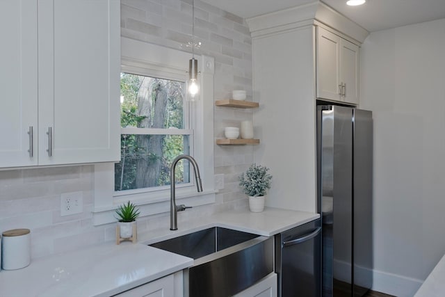 kitchen featuring backsplash, white cabinetry, sink, pendant lighting, and stainless steel appliances