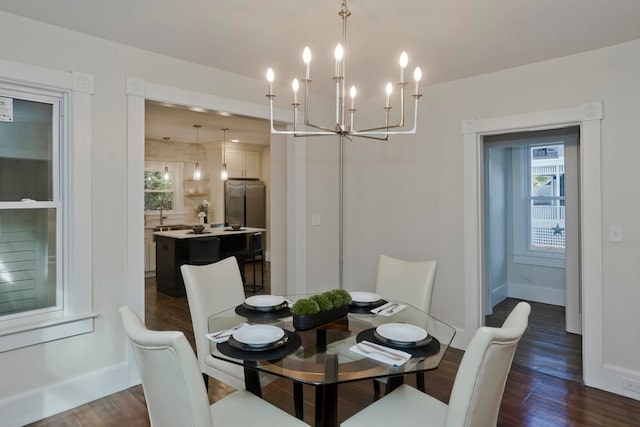 dining space with dark wood-type flooring and a notable chandelier