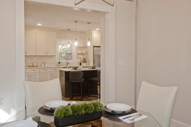 kitchen featuring sink, white cabinets, decorative light fixtures, and tasteful backsplash