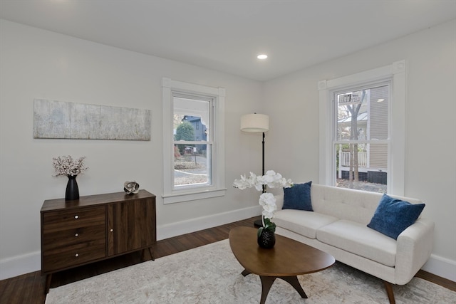 living area with a notable chandelier and dark hardwood / wood-style flooring