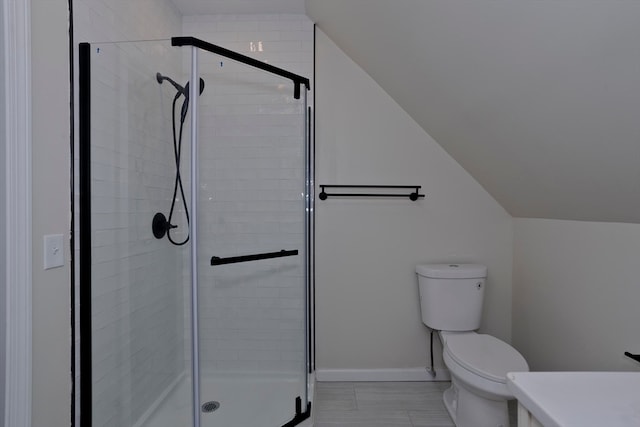 bathroom with vanity, lofted ceiling, toilet, and walk in shower