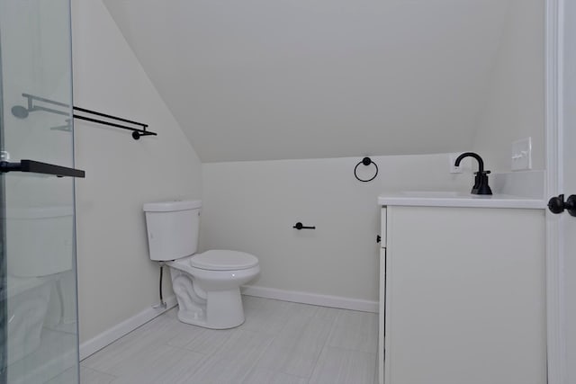 bathroom with vanity, toilet, vaulted ceiling, and an enclosed shower