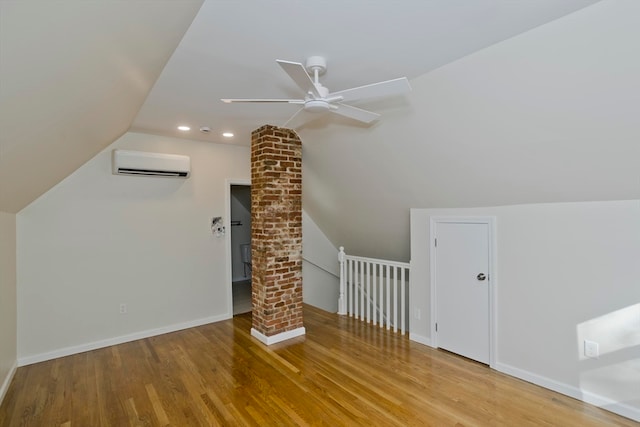 bonus room with ceiling fan, lofted ceiling, light hardwood / wood-style flooring, and a wall mounted air conditioner