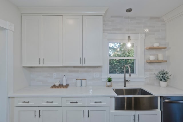 kitchen featuring white cabinets, tasteful backsplash, stainless steel dishwasher, and sink