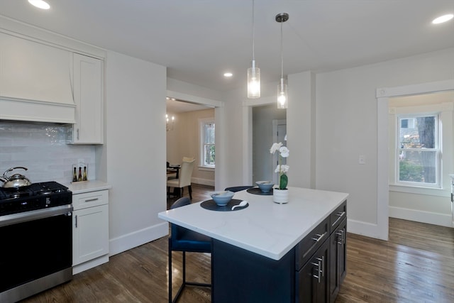 kitchen with white cabinetry, dark wood-type flooring, a kitchen island, and stainless steel stove