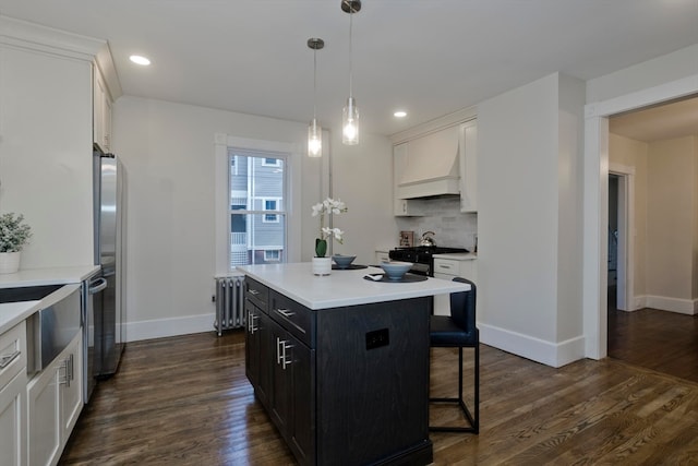 kitchen featuring dark hardwood / wood-style floors, a center island, radiator heating unit, and white cabinetry