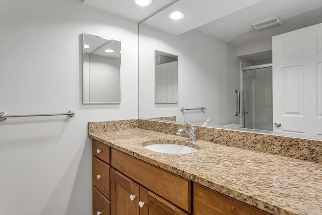 bathroom with toilet, an enclosed shower, and vanity