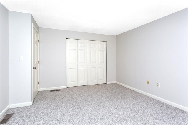 unfurnished bedroom with a closet and carpet flooring