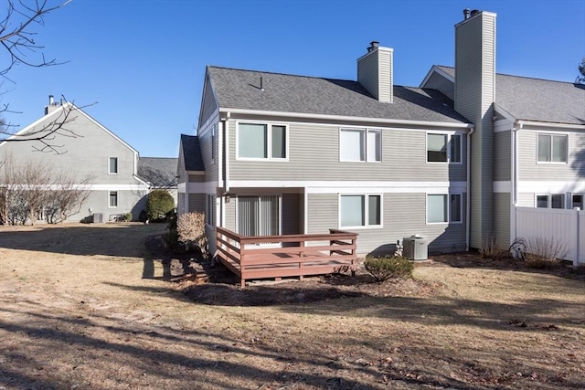 rear view of property featuring central AC, a deck, and a yard