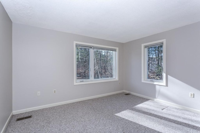 carpeted spare room with a textured ceiling