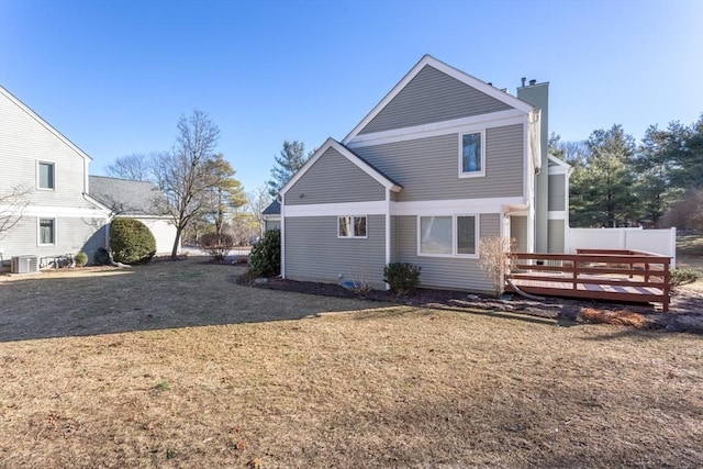 back of property with a lawn, central AC, and a deck