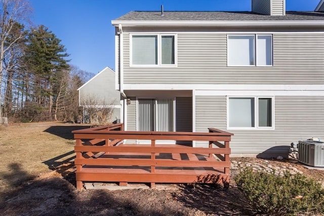 rear view of property featuring central AC unit and a wooden deck