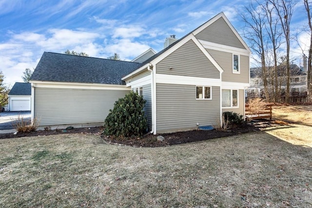 view of property exterior with a garage and a lawn