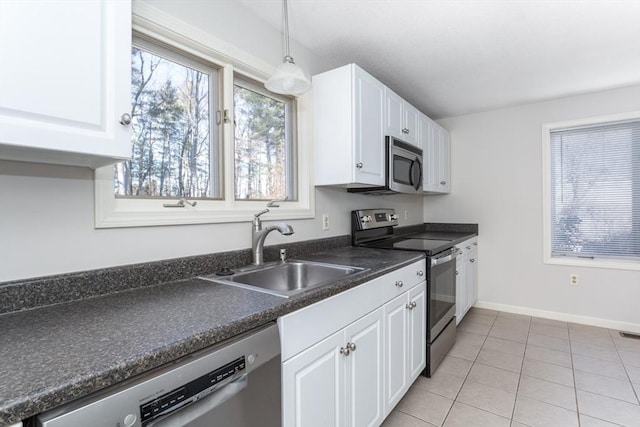 kitchen with stainless steel appliances, sink, decorative light fixtures, white cabinets, and light tile patterned flooring