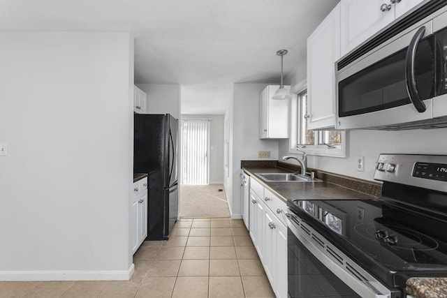 kitchen with pendant lighting, light colored carpet, white cabinets, appliances with stainless steel finishes, and sink