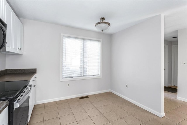 kitchen featuring light tile patterned flooring, white cabinetry, and stainless steel electric range oven