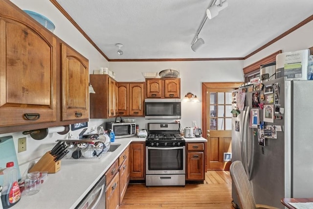 388 Arborway, Boston, MA 02130 - kitchen with stainless steel appliances, brown cabinetry, crown molding, light wood-style floors, and light countertops
