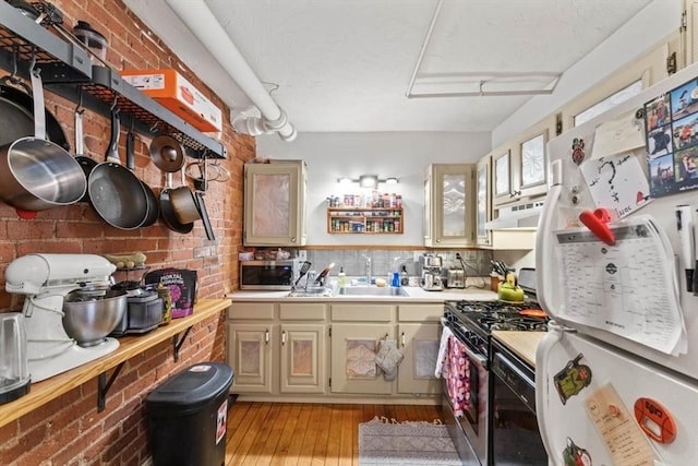 388 Arborway, Boston, MA 02130 - kitchen with stainless steel appliances, a sink, light countertops, light wood-style floors, and under cabinet range hood
