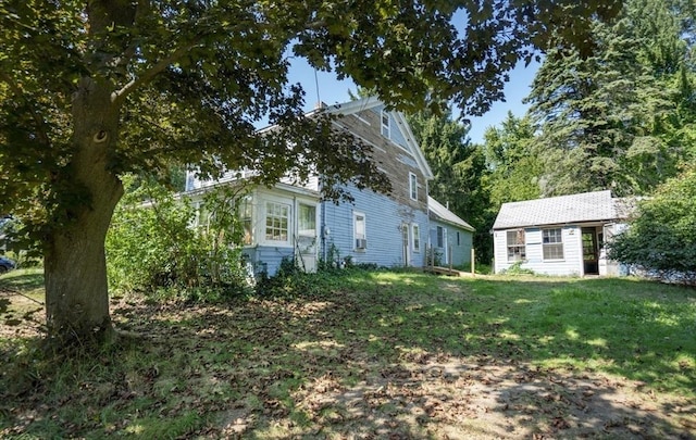 view of front of home with an outbuilding and a front yard