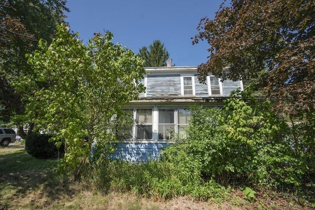 view of property exterior featuring a sunroom