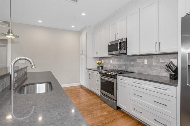 2 Inwood Dr Unit 3003, Woburn, MA 01801 - kitchen with stainless steel appliances, a sink, white cabinets, light wood-style floors, and backsplash