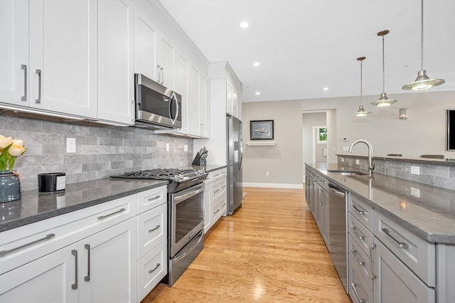 2 Inwood Dr Unit 3003, Woburn, MA 01801 - kitchen with stainless steel appliances, a sink, white cabinetry, tasteful backsplash, and dark stone countertops