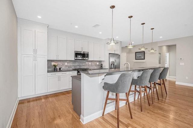 2 Inwood Dr Unit 3003, Woburn, MA 01801 - kitchen with appliances with stainless steel finishes, a kitchen island with sink, light wood-style flooring, baseboards, and recessed lighting