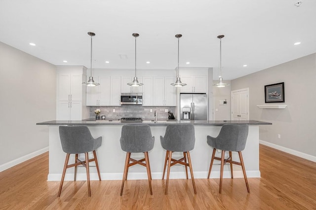 2 Inwood Dr Unit 3003, Woburn, MA 01801 - kitchen with appliances with stainless steel finishes, white cabinetry, a spacious island, backsplash, and baseboards