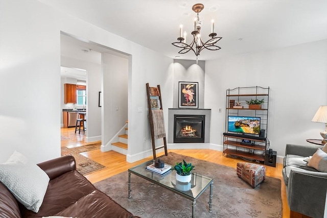 26-B Lake St Unit 26B, Somerville, MA 02143 - living area featuring light wood finished floors, a chandelier, a glass covered fireplace, stairway, and baseboards