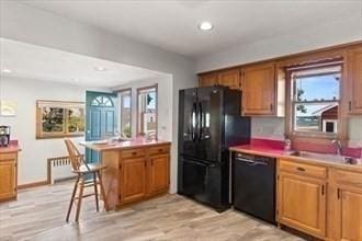 16 Simmons Rd, Nahant, MA 01908 - kitchen featuring a breakfast bar, a peninsula, black appliances, and plenty of natural light