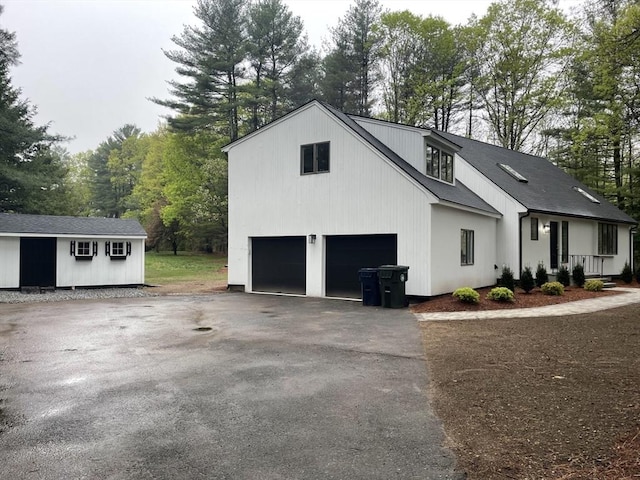 47 Woodcock Ln, Marlborough, MA 01752 - view of side of property featuring driveway, an attached garage, and view of wooded area