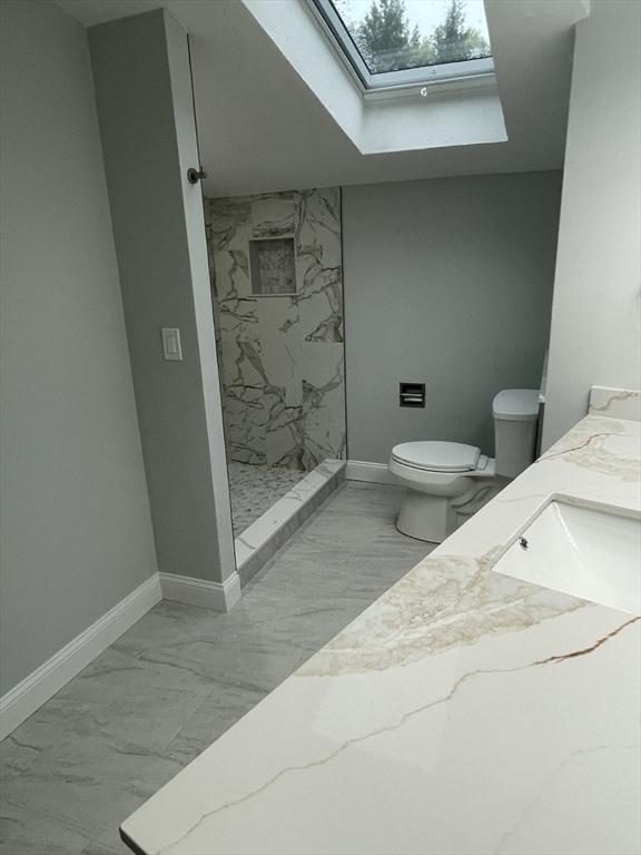 47 Woodcock Ln, Marlborough, MA 01752 - full bathroom with marble finish flooring, a skylight, toilet, a marble finish shower, and baseboards