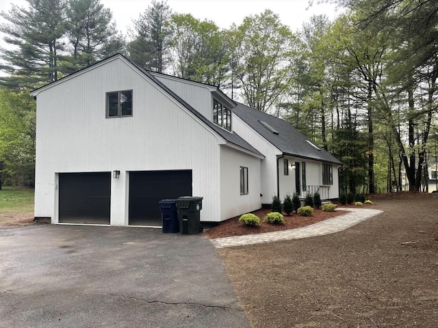 47 Woodcock Ln, Marlborough, MA 01752 - view of property exterior featuring asphalt driveway, an attached garage, and view of wooded area