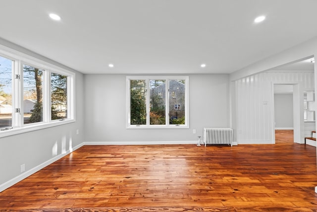 spare room featuring light wood-type flooring and radiator