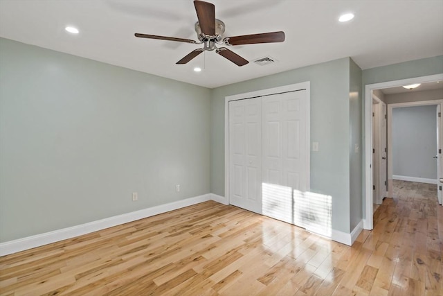 unfurnished bedroom featuring ceiling fan, light hardwood / wood-style floors, and a closet