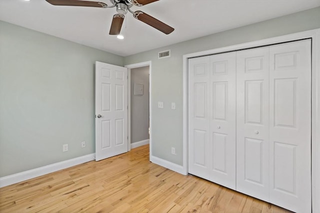 unfurnished bedroom with light hardwood / wood-style flooring, a closet, and ceiling fan