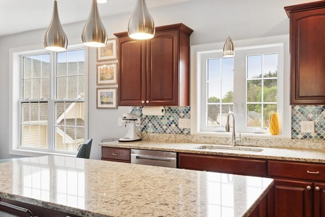 kitchen featuring a sink, decorative light fixtures, backsplash, stainless steel dishwasher, and light stone countertops