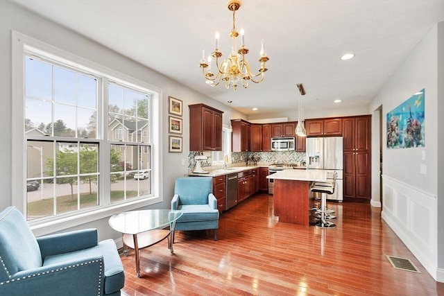 kitchen featuring a breakfast bar area, a notable chandelier, visible vents, light countertops, and appliances with stainless steel finishes