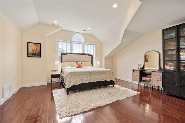 bedroom with baseboards, hardwood / wood-style floors, visible vents, and vaulted ceiling