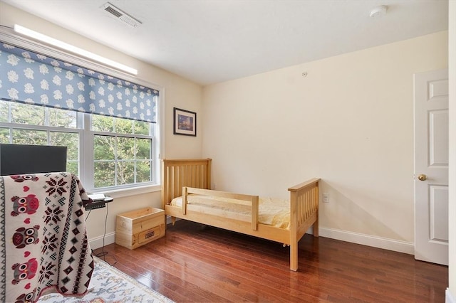 bedroom with hardwood / wood-style flooring, baseboards, and visible vents