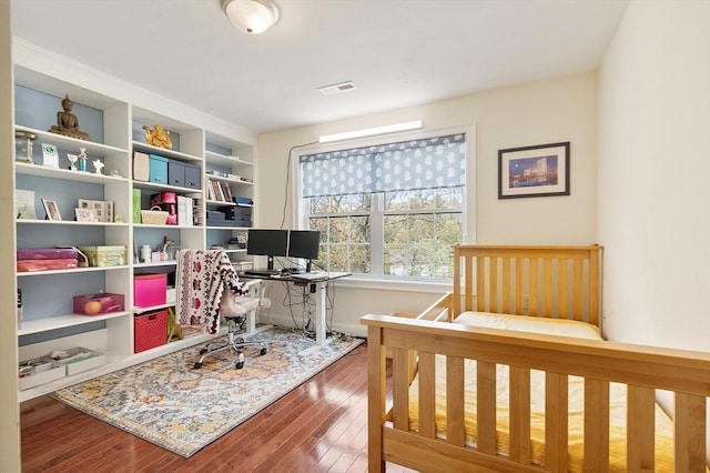 bedroom with baseboards and hardwood / wood-style flooring