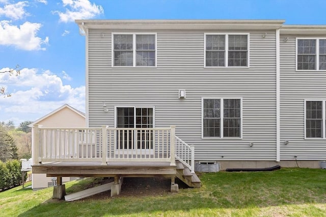 rear view of property with a yard and a wooden deck