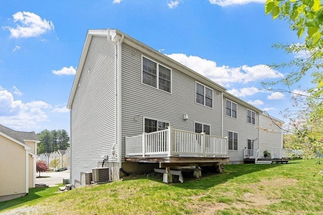 rear view of house with a yard, a wooden deck, and central AC unit