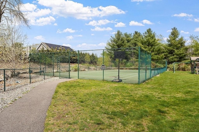 view of sport court featuring a yard, fence, and a gate