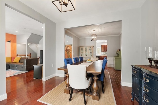 dining area with baseboards, ornamental molding, dark wood finished floors, and a chandelier