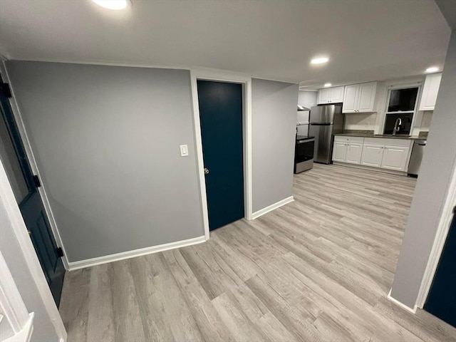 7 Coolidge St, Hudson, MA 01749 - kitchen with appliances with stainless steel finishes, dark countertops, light wood-style floors, white cabinets, and baseboards