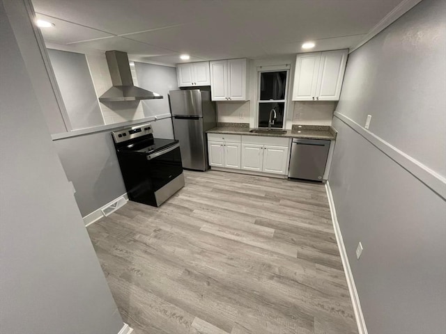 7 Coolidge St, Hudson, MA 01749 - kitchen featuring wall chimney exhaust hood, stainless steel appliances, a sink, white cabinetry, and baseboards