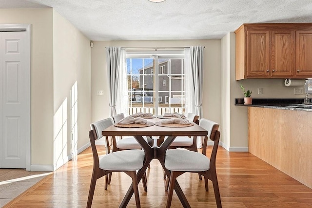 dining room featuring a textured ceiling and light wood-type flooring