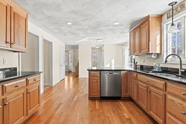 kitchen featuring sink, dishwasher, decorative light fixtures, kitchen peninsula, and light wood-type flooring